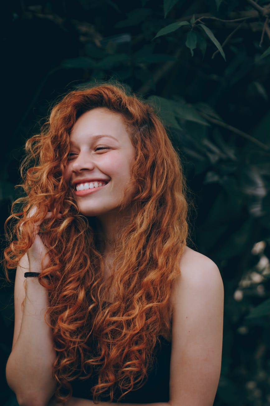Young woman with red hair and she is smiling.